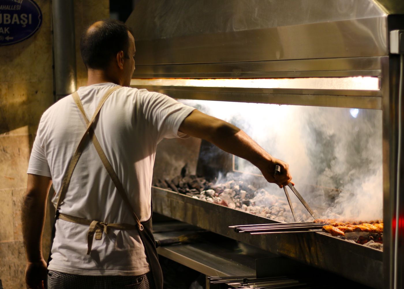 Kok griller spyd over kulgrillen hos Efendi